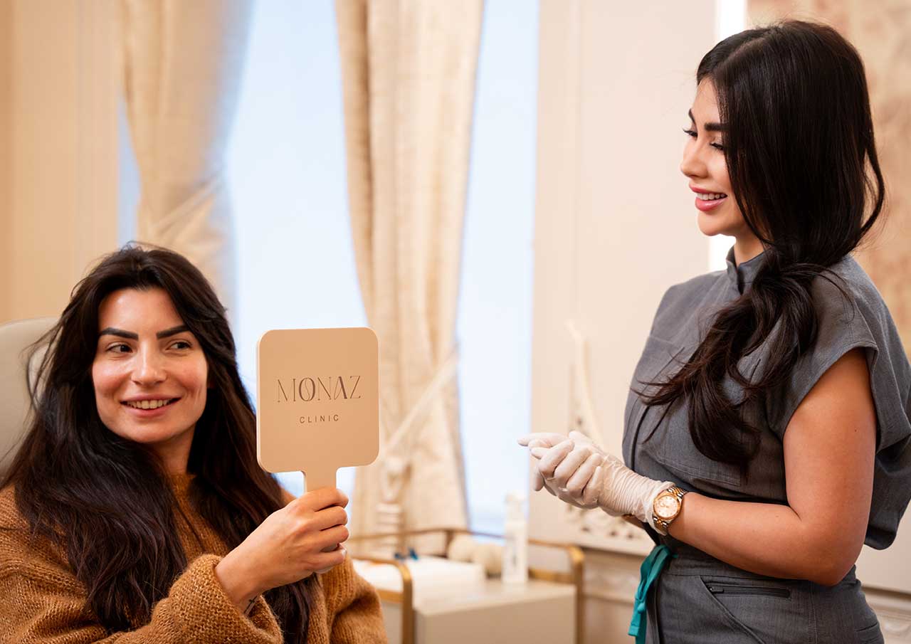 Patient reviewing results during Teeth Grinding and Jaw Clenching (Bruxism) consultation at Monaz Clinic for masseter muscle treatment.